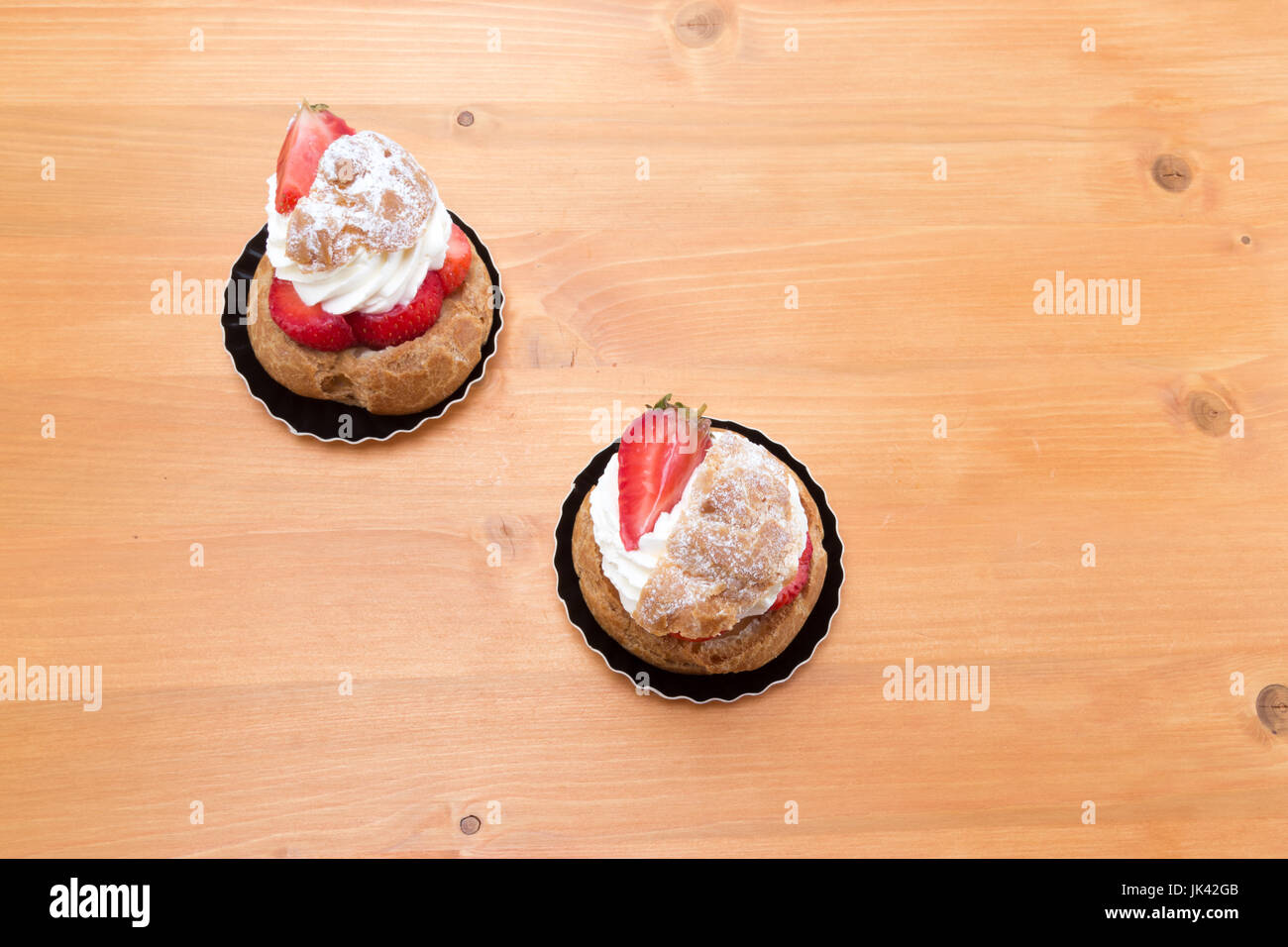 Chou aux fraises - Tarte aux fraises et crème fouettée. Vue de dessus sur une table en chêne. Banque D'Images