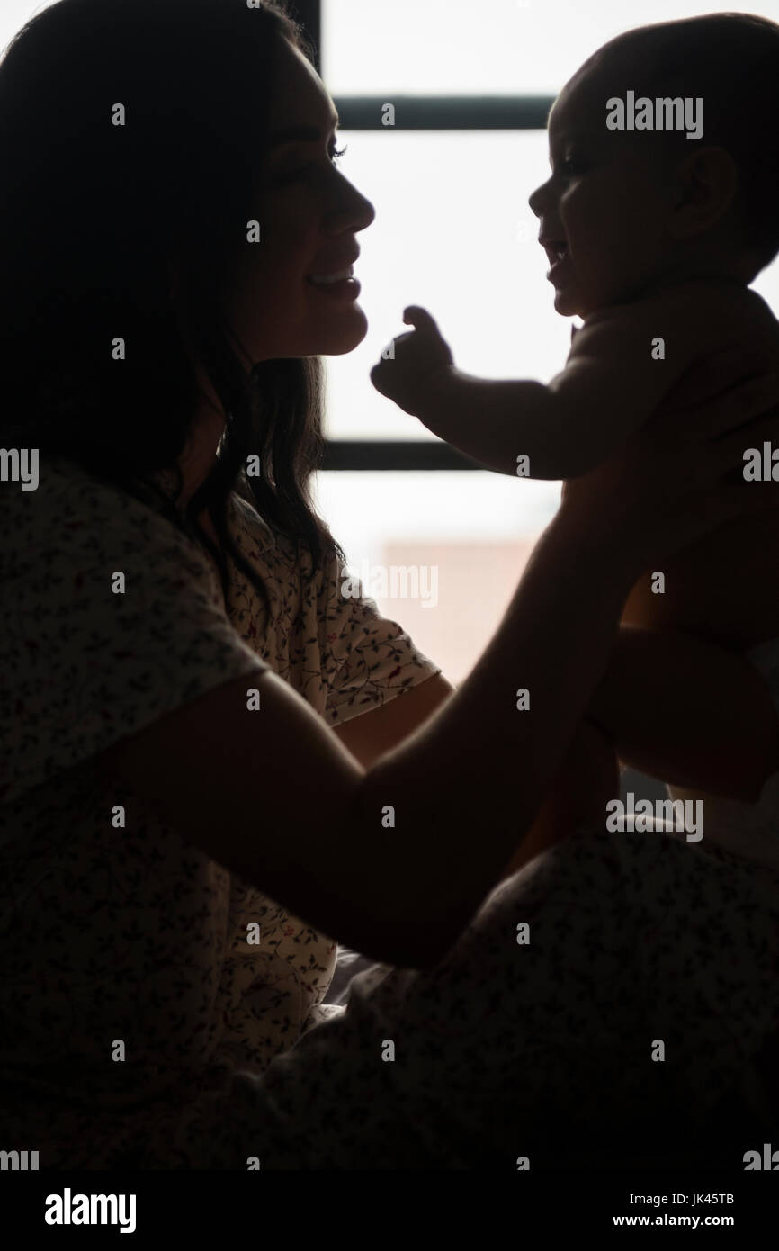 Silhouette of Caucasian mother holding baby son Banque D'Images