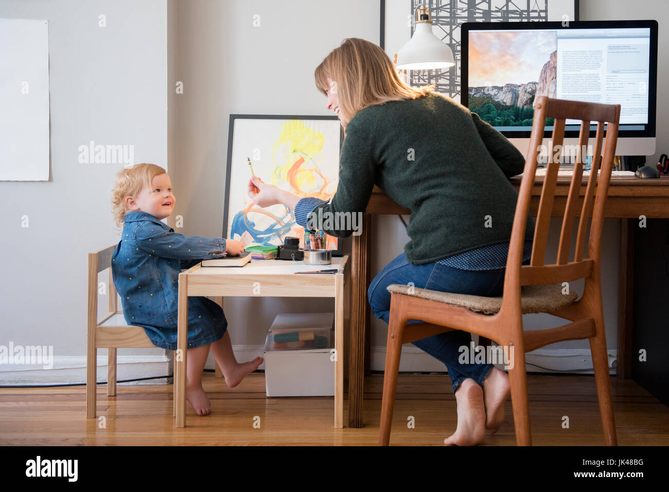 Portrait de Mère et fille jouer in home office Banque D'Images