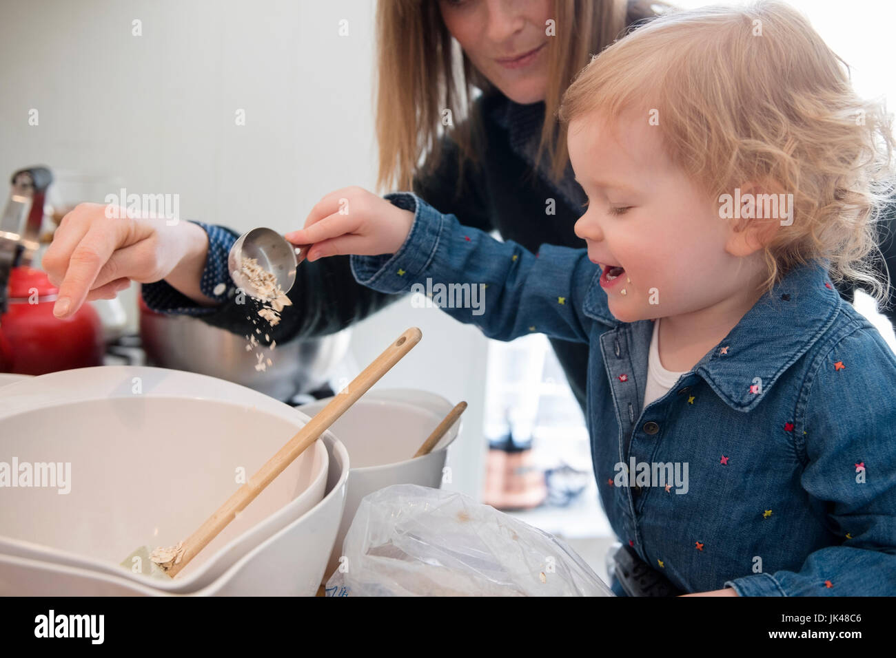 Caucasian girl la cuisson avec la mère dans la cuisine Banque D'Images