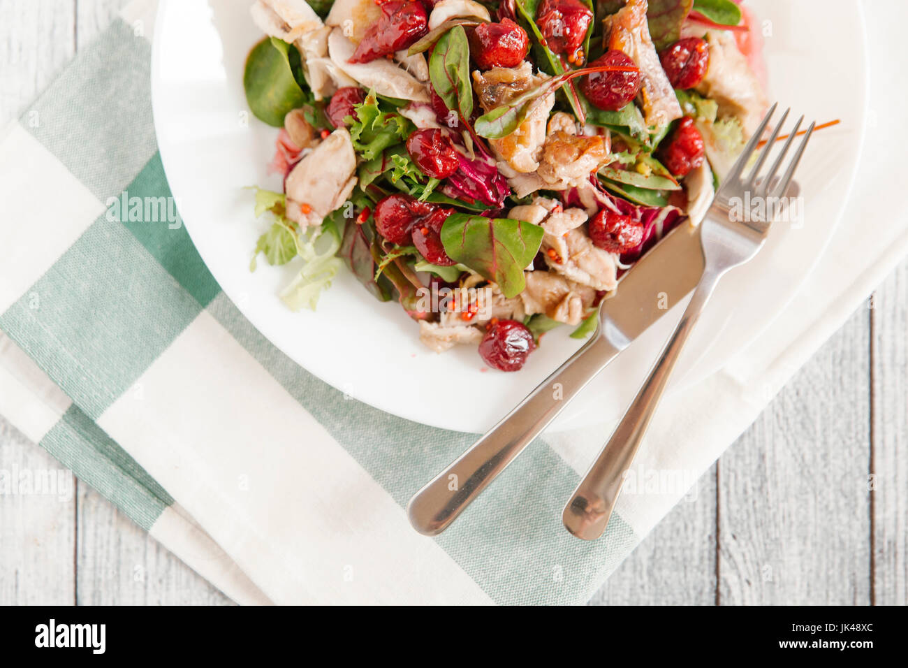 Assiette de salade avec du poulet et de la sauce aux cerises Banque D'Images