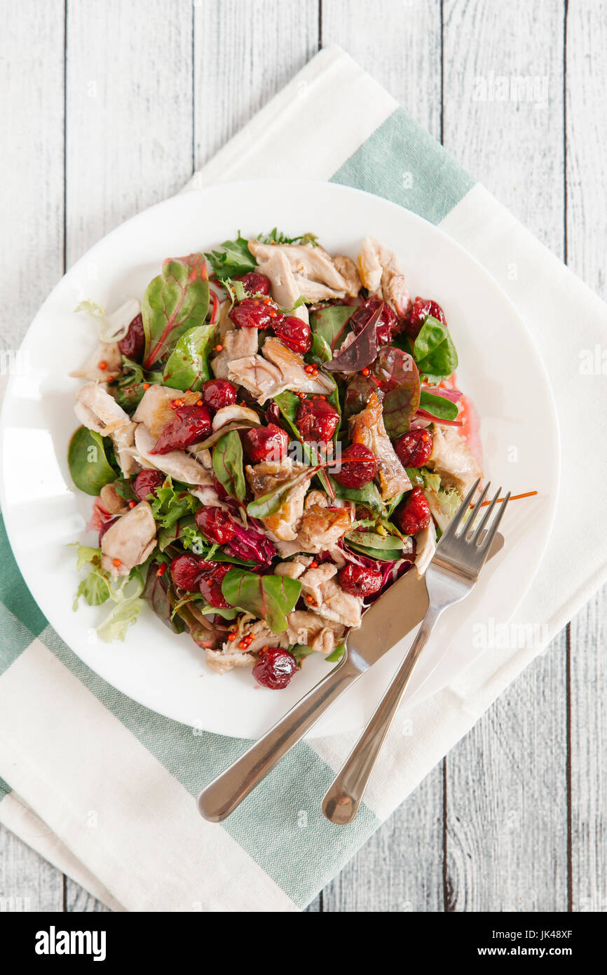 Assiette de salade avec du poulet et de la sauce aux cerises Banque D'Images