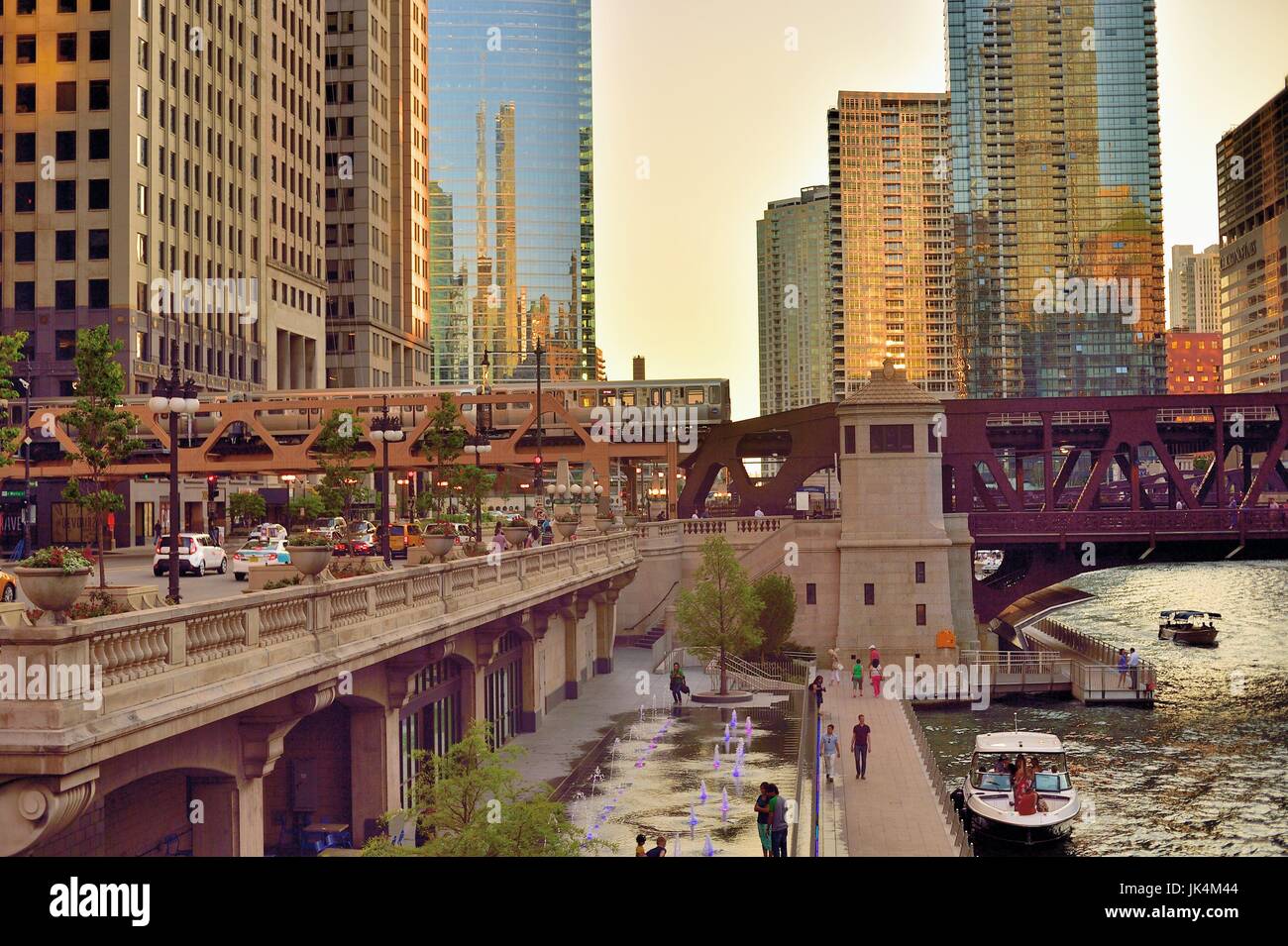 Comme le soleil qui crée reflecitons Chicagl sur une variété de surfaces de construction, une ligne Brune CTA du train traverse la rivière Chicago. Banque D'Images