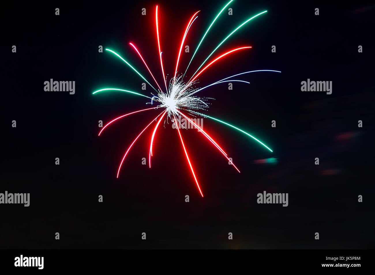 Mousseux rouge vert jaune célébration d'artifice au-dessus ciel étoilé. Le jour de l'indépendance, le 4 juillet, jour de l'an saluer l'arrière-plan. Banque D'Images