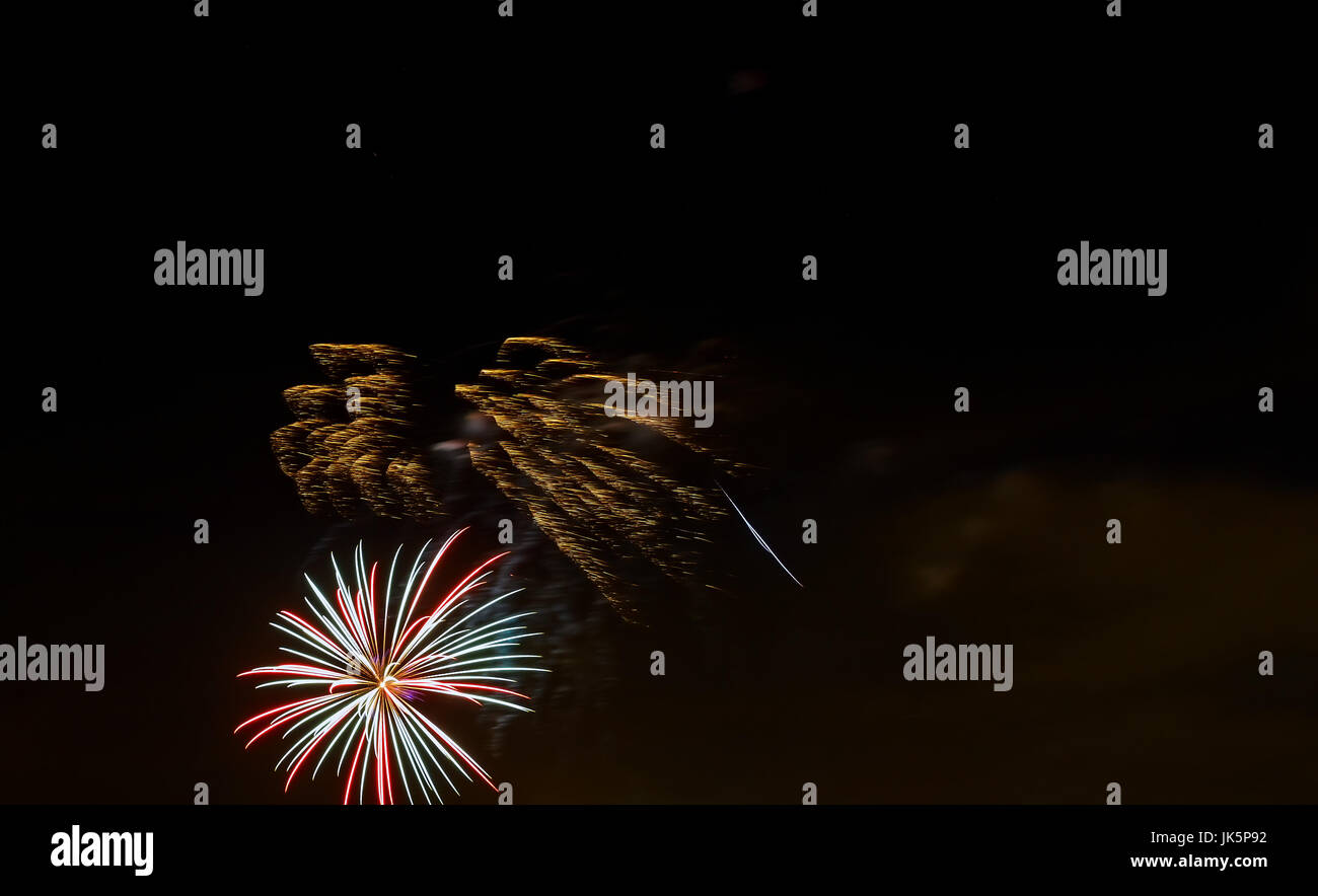 Mousseux rouge vert jaune célébration d'artifice au-dessus ciel étoilé. Le jour de l'indépendance, le 4 juillet, jour de l'an saluer l'arrière-plan. Banque D'Images