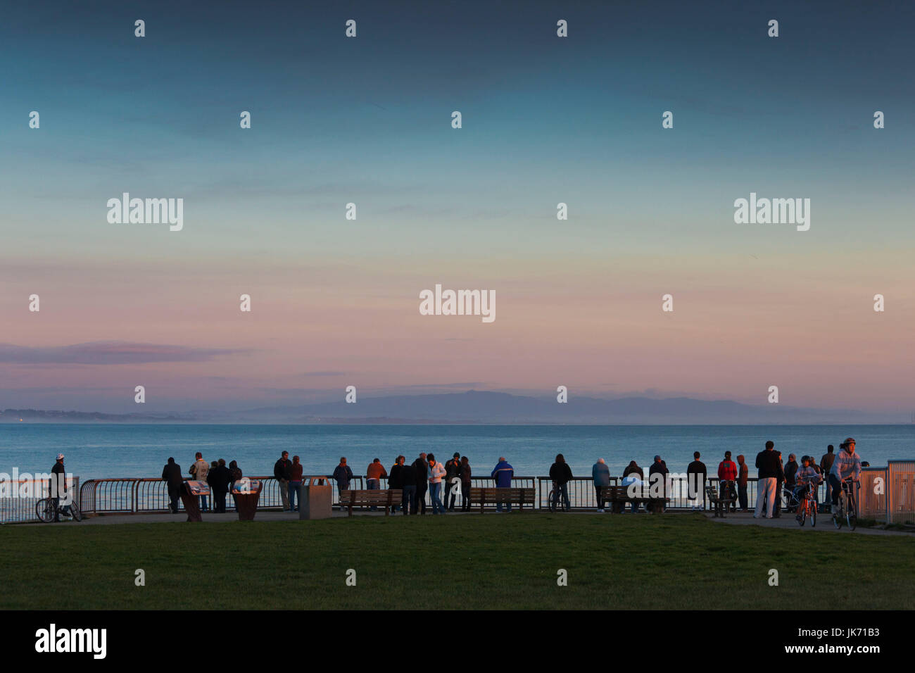 États-unis, Californie, côte centrale, Santa Cruz, Lighthouse Field State Beach, les gens à regarder les surfeurs sur Steamers Lane, coucher du soleil Banque D'Images