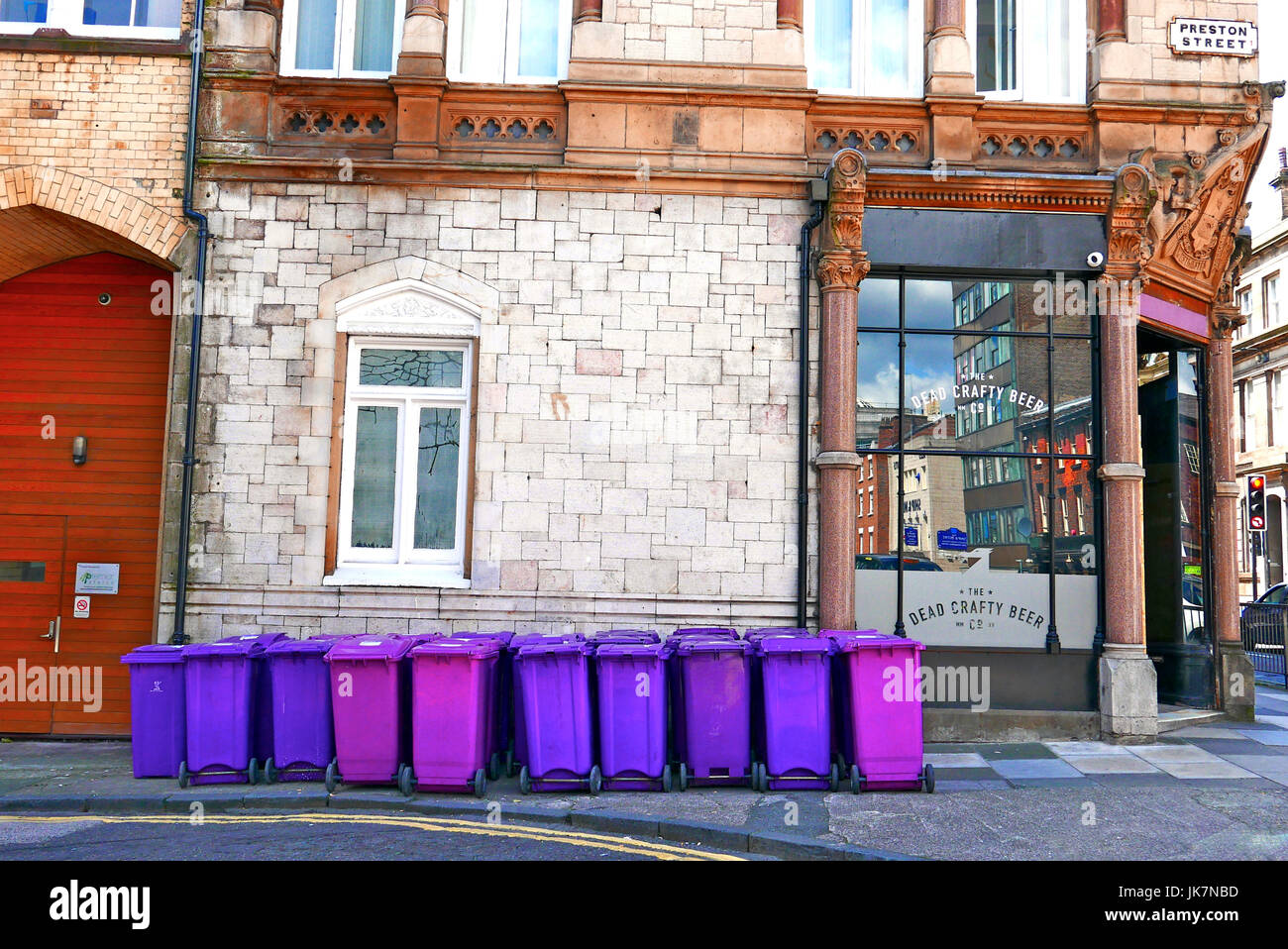 Bleu et violet wheelie bins alignés en dehors de la zone morte Crafty Beer Company,Preston Street, Liverpool, Royaume-Uni Banque D'Images