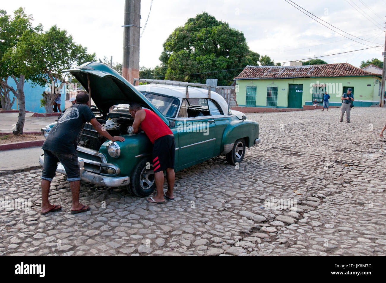 Les hommes cubains travaillant à peine de vieilles voitures américaines des années 1950 à Trinidad Cuba Banque D'Images