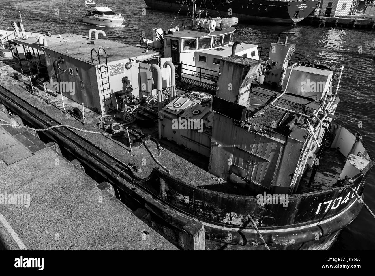 Rusty de vieux barge amarrée le long avec remorqueur moderne Banque D'Images