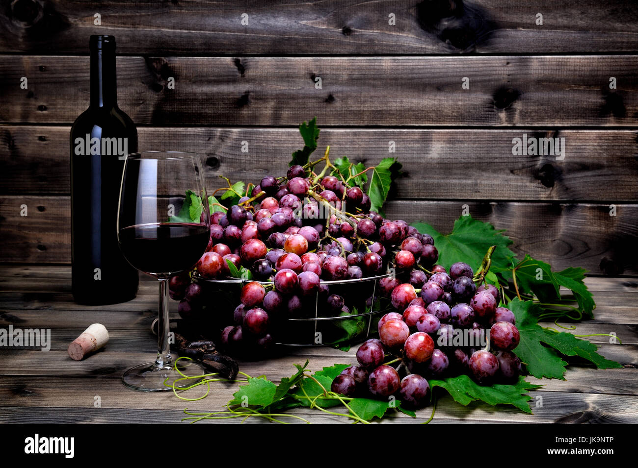 Les raisins rouges frais bouquet allongé sur feuilles sur une vieille table en bois. Banque D'Images