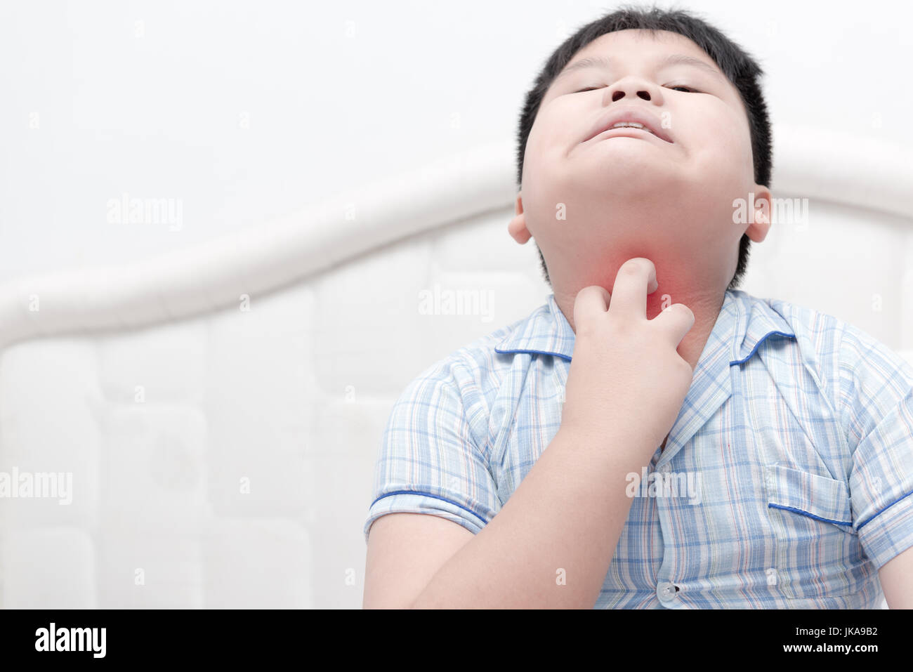 Asian boy obèses rayer la démangeaison avec main sur lit, concept avec Santé et médecine Banque D'Images