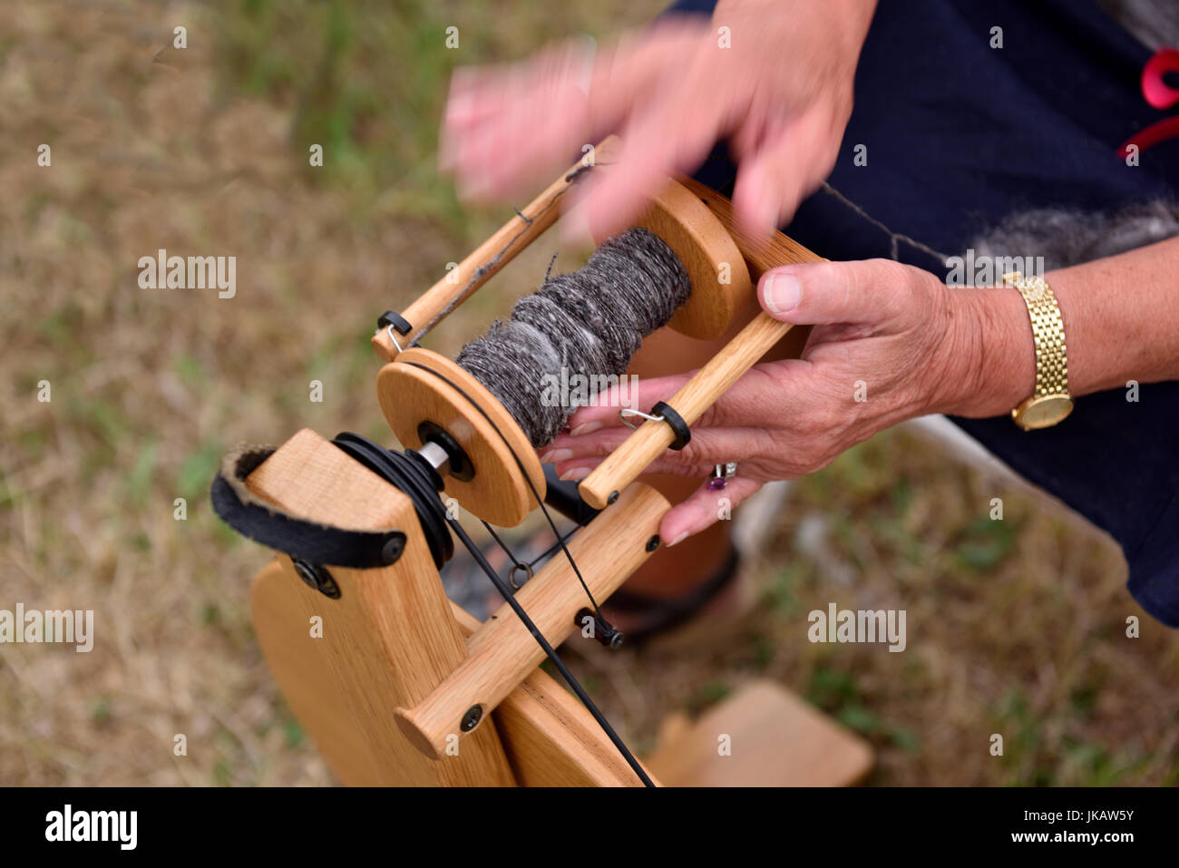 Close-up of woman's hands fil conducteur sur la roue tournante bobbin Banque D'Images