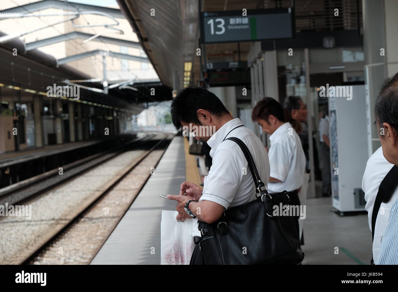 Salaire japonais hommes attendant le train Banque D'Images