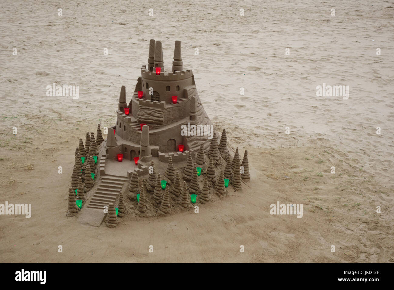 Château de sable à la plage avec des bougies colorées Banque D'Images