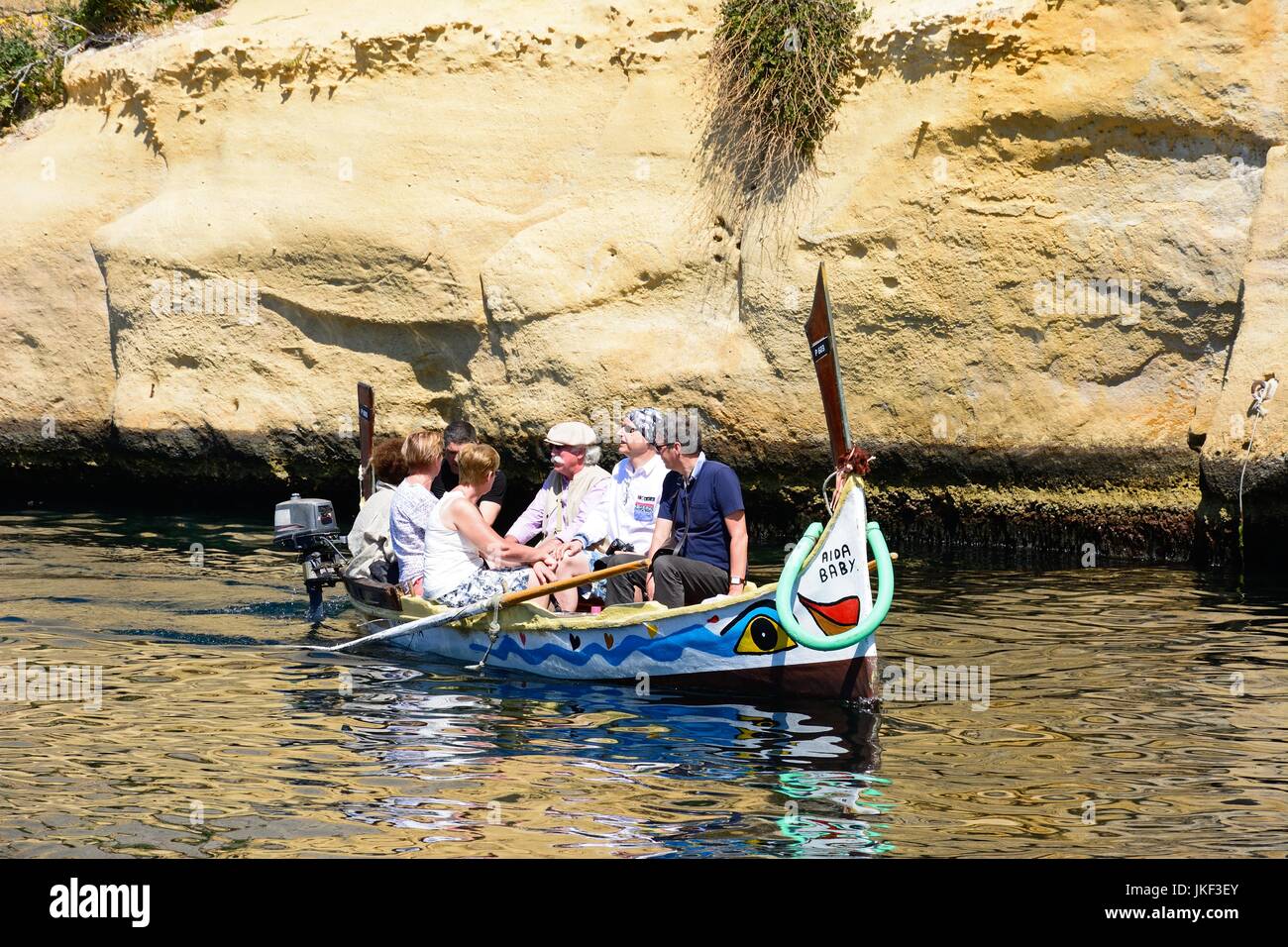 Les passagers à bord d'un bateau-taxi Dghajsa traditionnelle maltaise dans une crique à côté de Fort San Angelo, Mdina, Malte, l'Europe. Banque D'Images