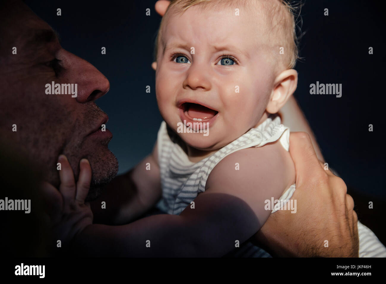 Portrait de pleurer petit garçon sur les bras de son père Banque D'Images