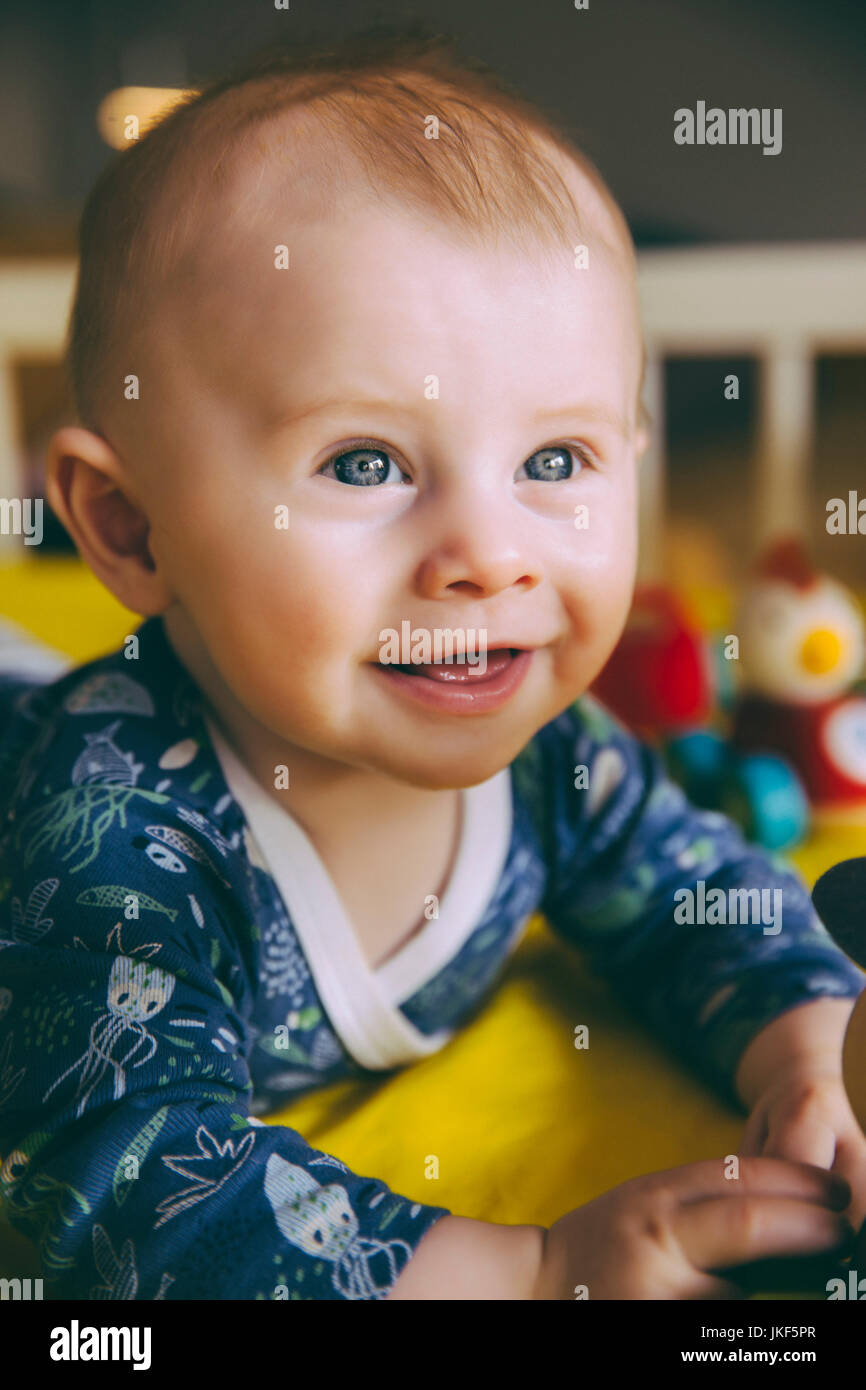 Portrait of happy baby boy dans son lit de bébé Banque D'Images