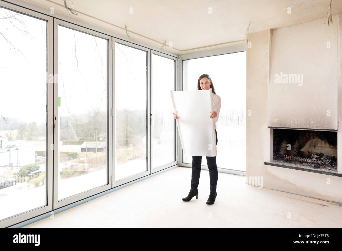 Femme en appartement vide avec plan Banque D'Images