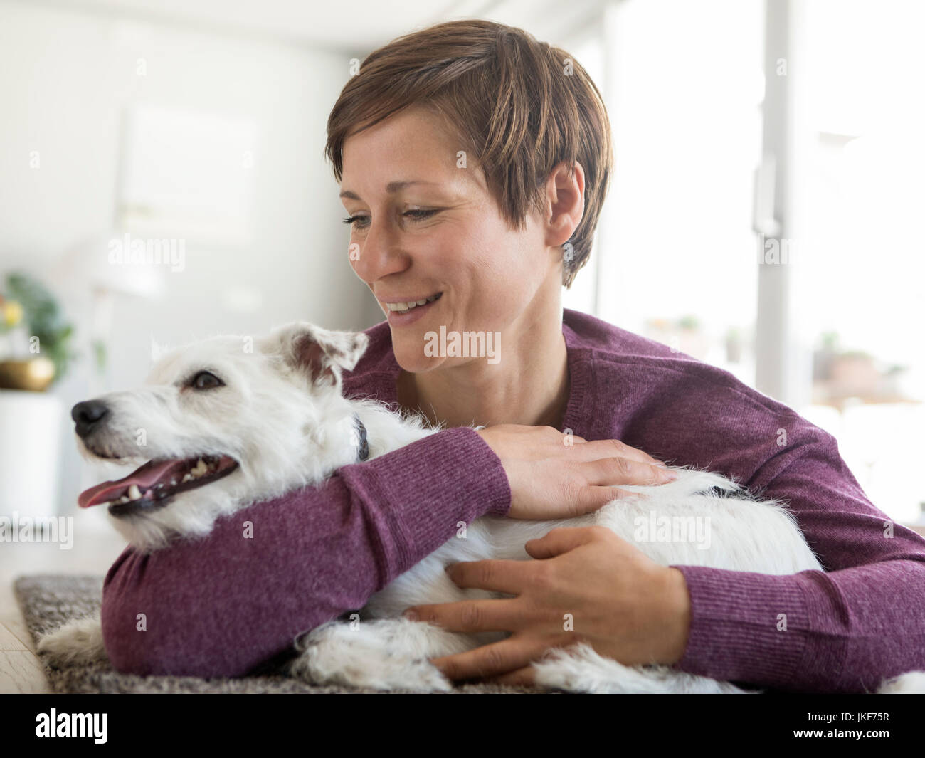 Woman hugging son chien à la maison Banque D'Images