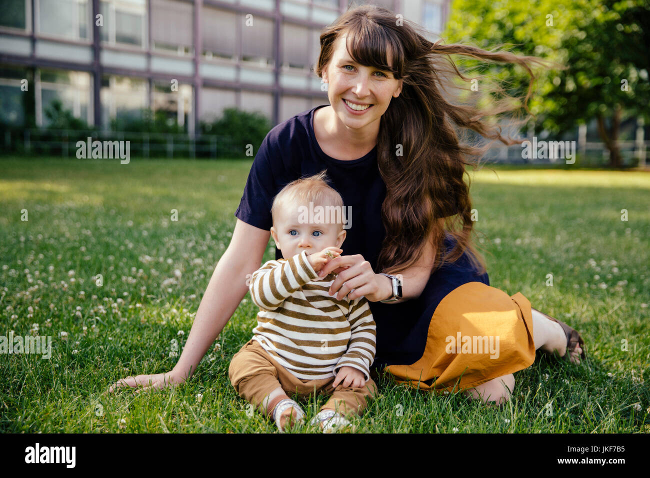 Happy mother sitting with her baby boy on a meadow Banque D'Images