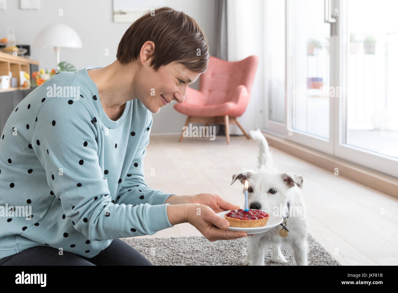 Femme présentant un gâteau d'anniversaire de son chien Banque D'Images