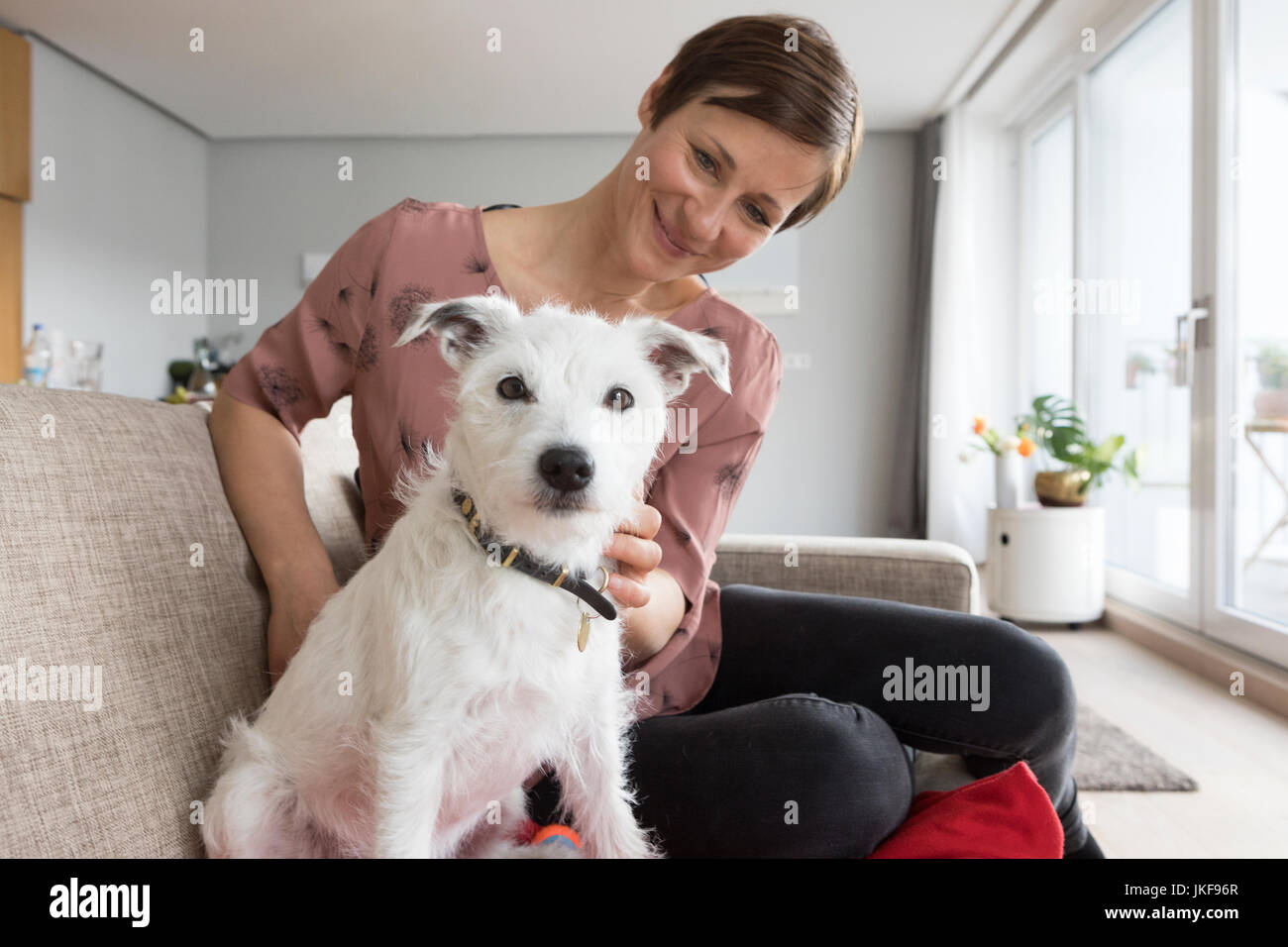 Femme et son chien assis ensemble sur le canapé Banque D'Images