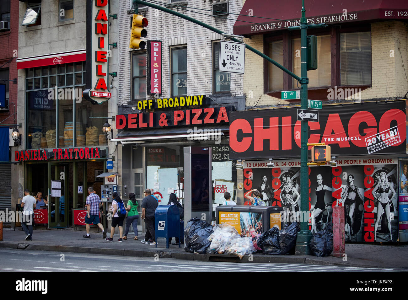 La ville de New York, Manhattan, la 8e Avenue et rue 45 boutiques à emporter avec des sacs poubelles sur le trottoir. Banque D'Images