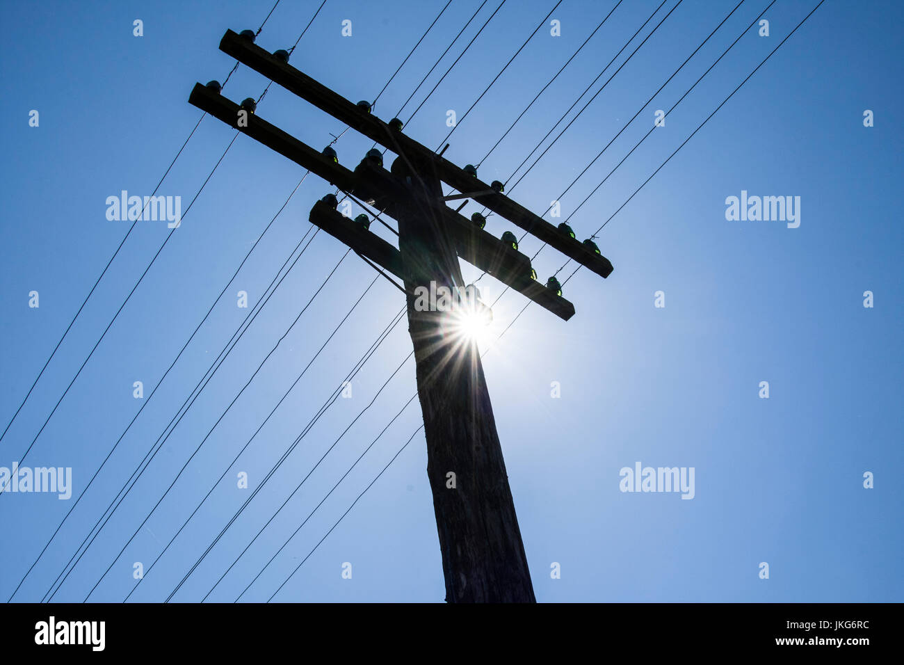 Treillis électriques avec ciel bleu et soleil dans l'arrière-plan Banque D'Images