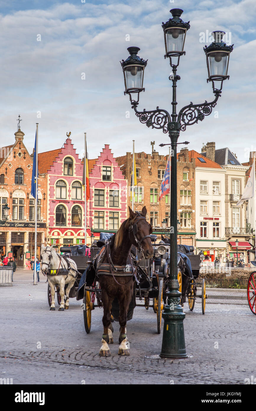 Voitures à cheval sur la Grand-Place de la ville médiévale de Bruges Matin, en Belgique. Banque D'Images