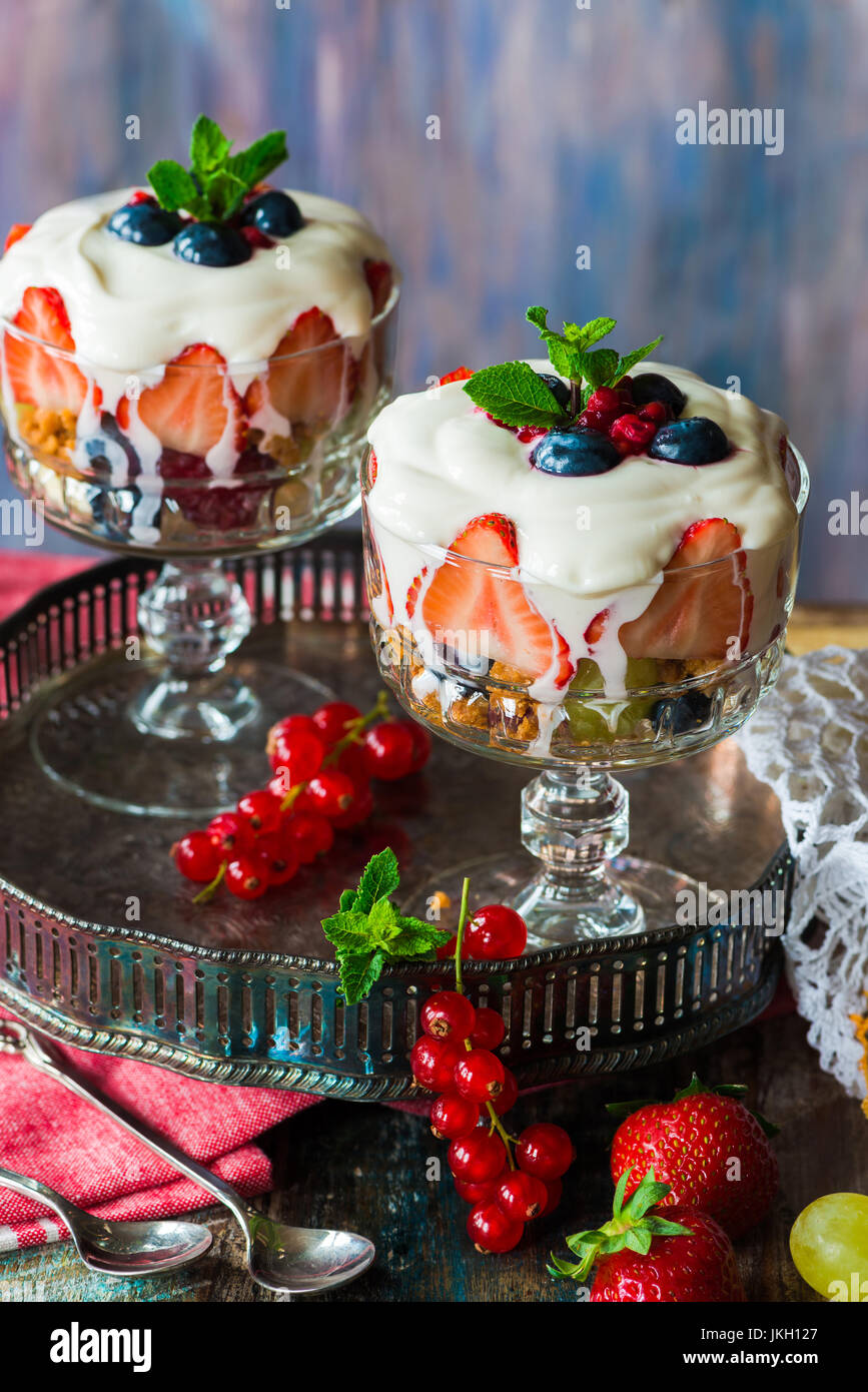 Salade de fruits aux fraises avec du yaourt au miel en bols en verre garni de menthe fraîche Banque D'Images