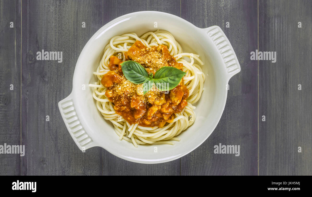 Plateau de spaghettis à la bolognaise avec sarriette hachée de bœuf et sauce tomate garnie de basilic, overhead view Banque D'Images