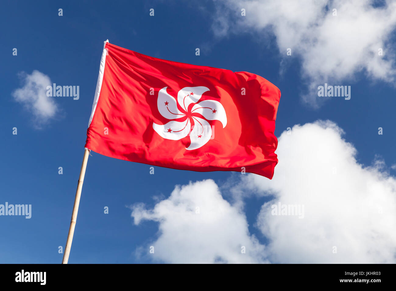 De brandir le drapeau de Hong Kong sur fond de ciel bleu nuageux Banque D'Images