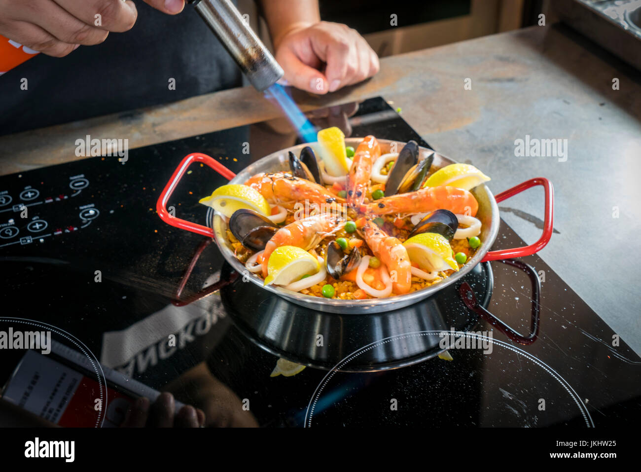 Chef, c'est la friture de fruits de mer paella avec brûleur Banque D'Images