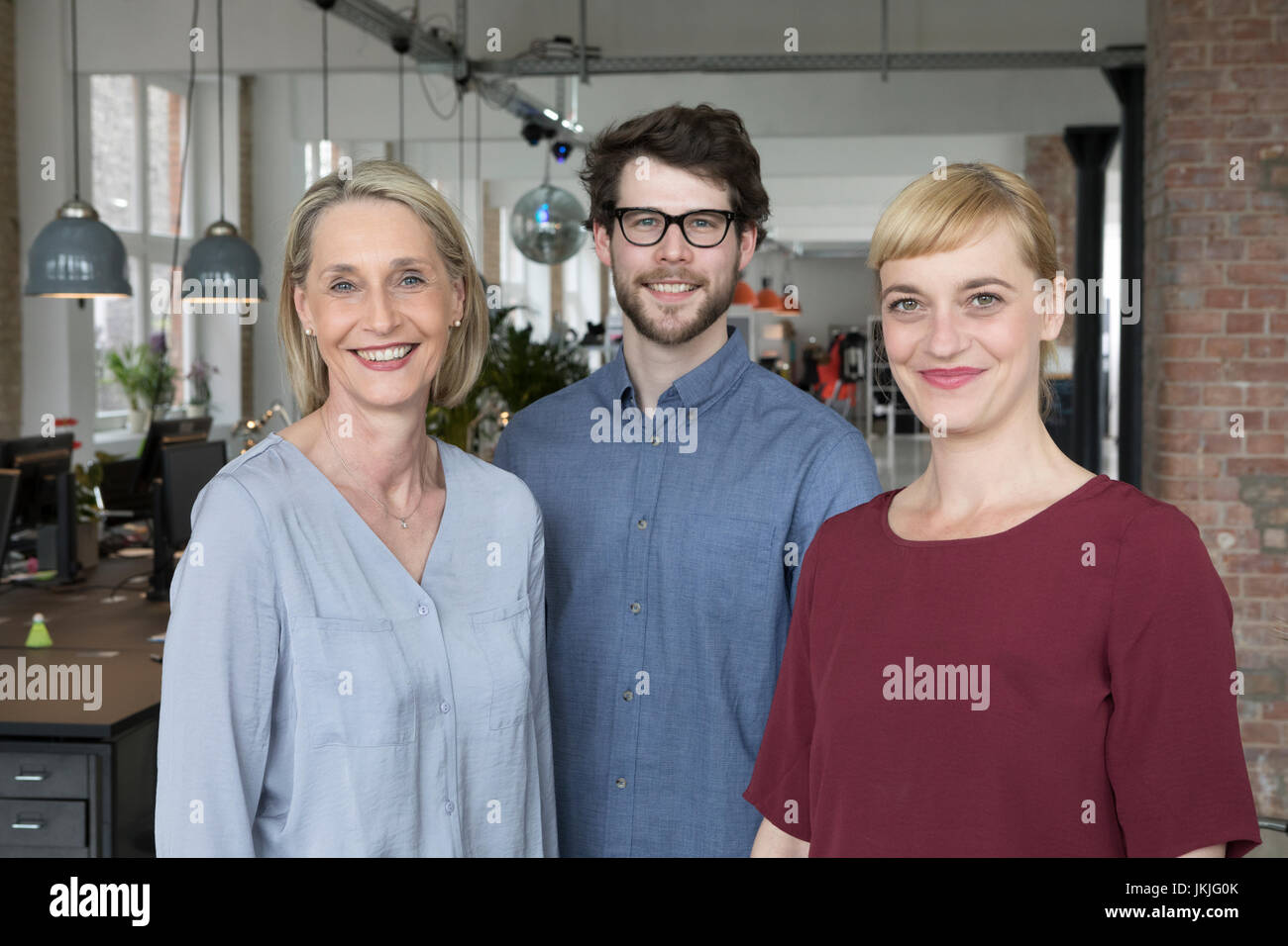 Trois smiling businesspeople in office Banque D'Images