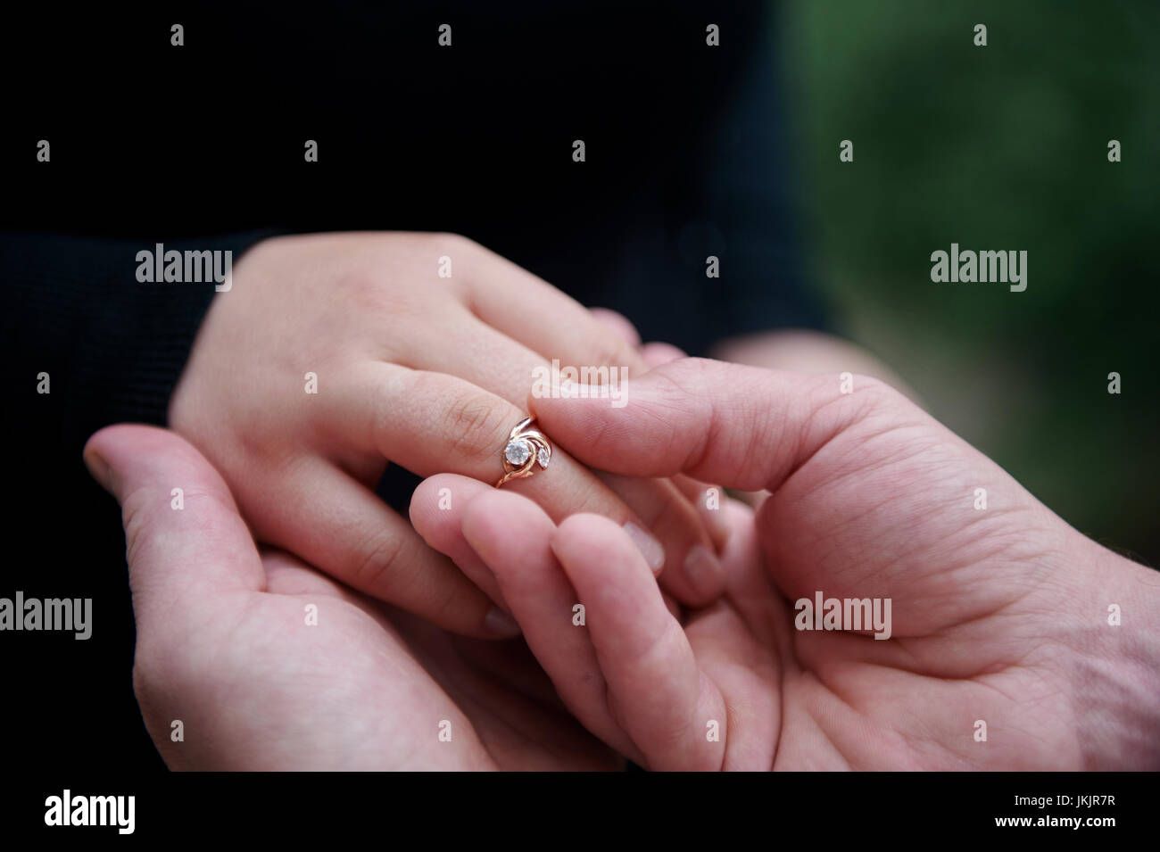 Homme habille une bague de fiançailles sur le doigt d'une femme. Banque D'Images