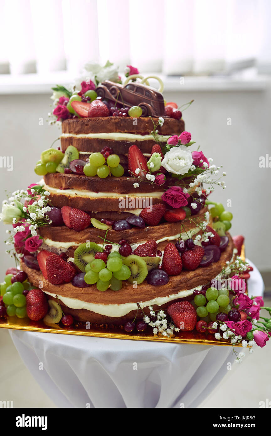 Beau gâteau de mariage avec des fruits sur la table. Banque D'Images