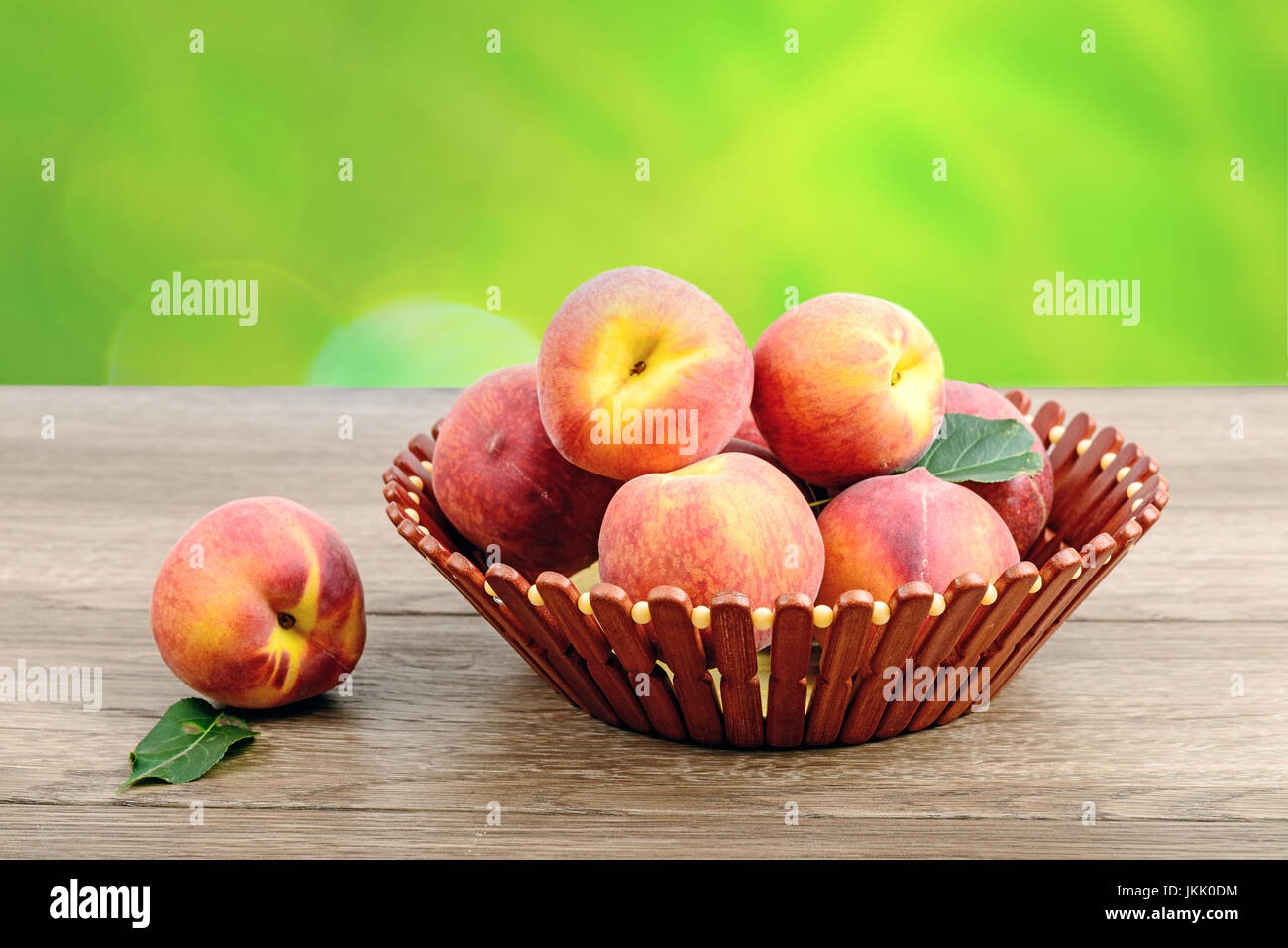 Sur les pêches juteux panier en bois et une table de jardin en Banque D'Images