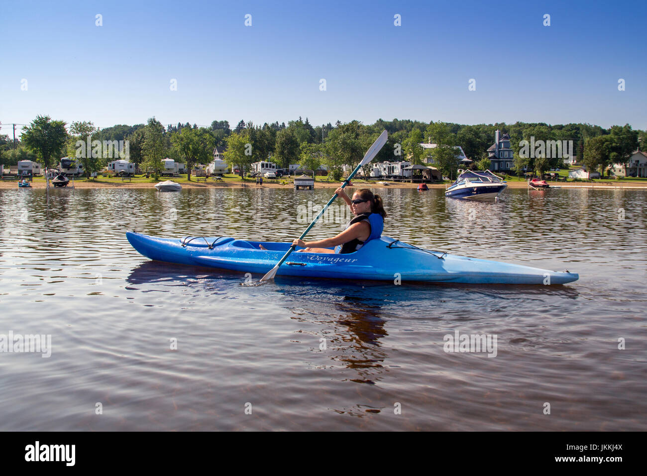 St-Gabriel-de-Brandon, Canada-20 Juillet 2017 : femme kayak seul au lac Maskinongé Lac à l'heure d'été en face de la plage Banque D'Images