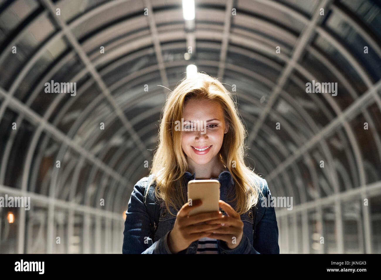 Femme dans la ville la nuit holding smartphone, sms. Banque D'Images