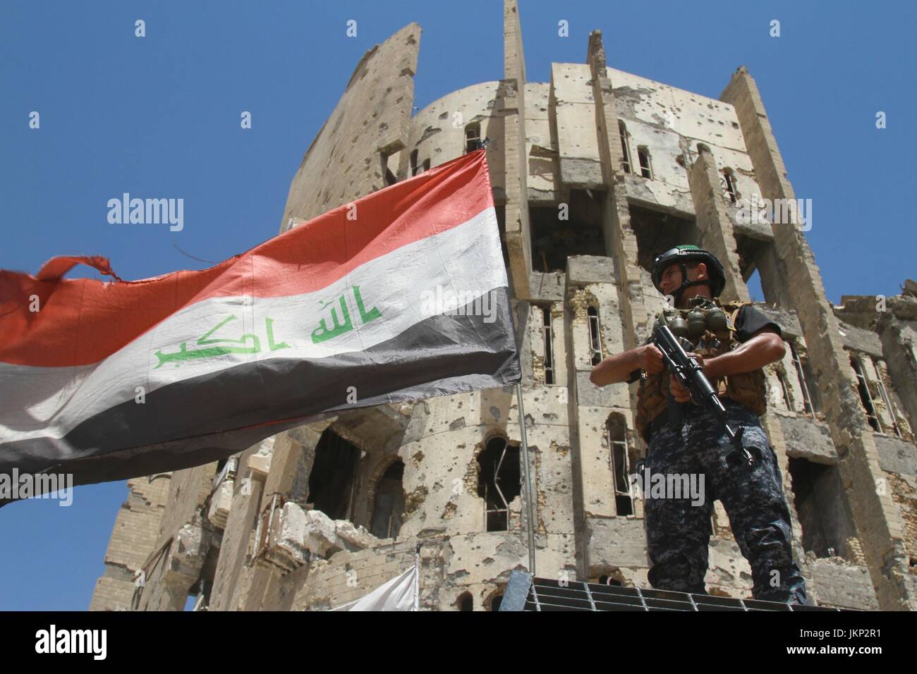 Mossoul, Irak. 24 juillet, 2017. Un soldat irakien monte la garde devant un bâtiment du gouvernement endommagés dans l'ouest de Mossoul, Irak, le 24 juillet 2017. Les forces iraquiennes ont poursuivi leurs opérations de nettoyage dans l'ouest de Mossoul à éradiquer toutes les menaces possibles restantes de l'État islamique (EST). Le 10 juillet, le Premier ministre irakien Haider al-Abadi a officiellement déclaré que Mossoul, le dernier bastion de l'Est en Irak, a été libéré de contrôle est, après neuf mois de combats acharnés. Yaser Crédit : Jawad/Xinhua/Alamy Live News Banque D'Images