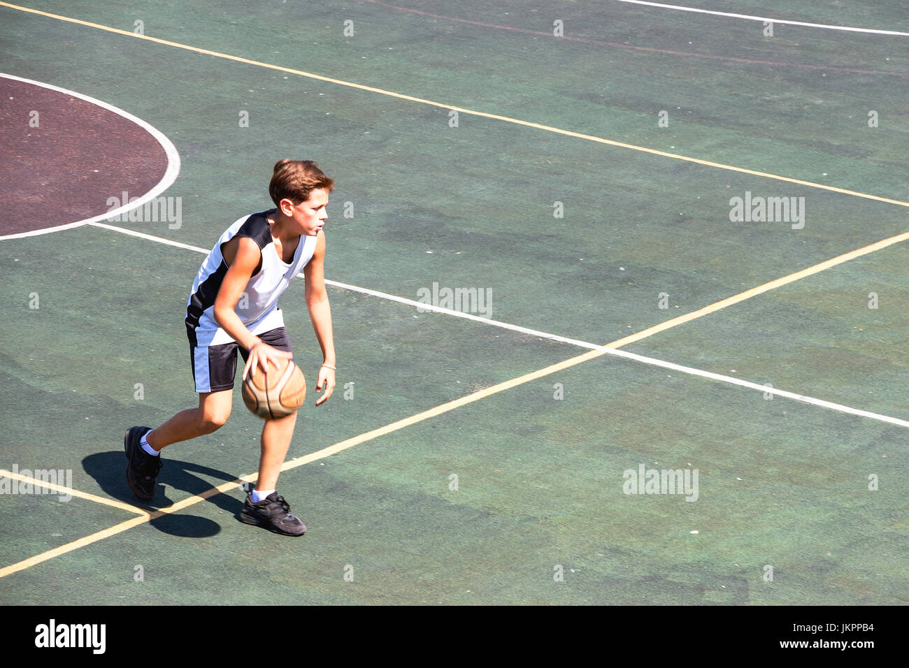 Garçon sur un terrain de basket-ball Banque D'Images