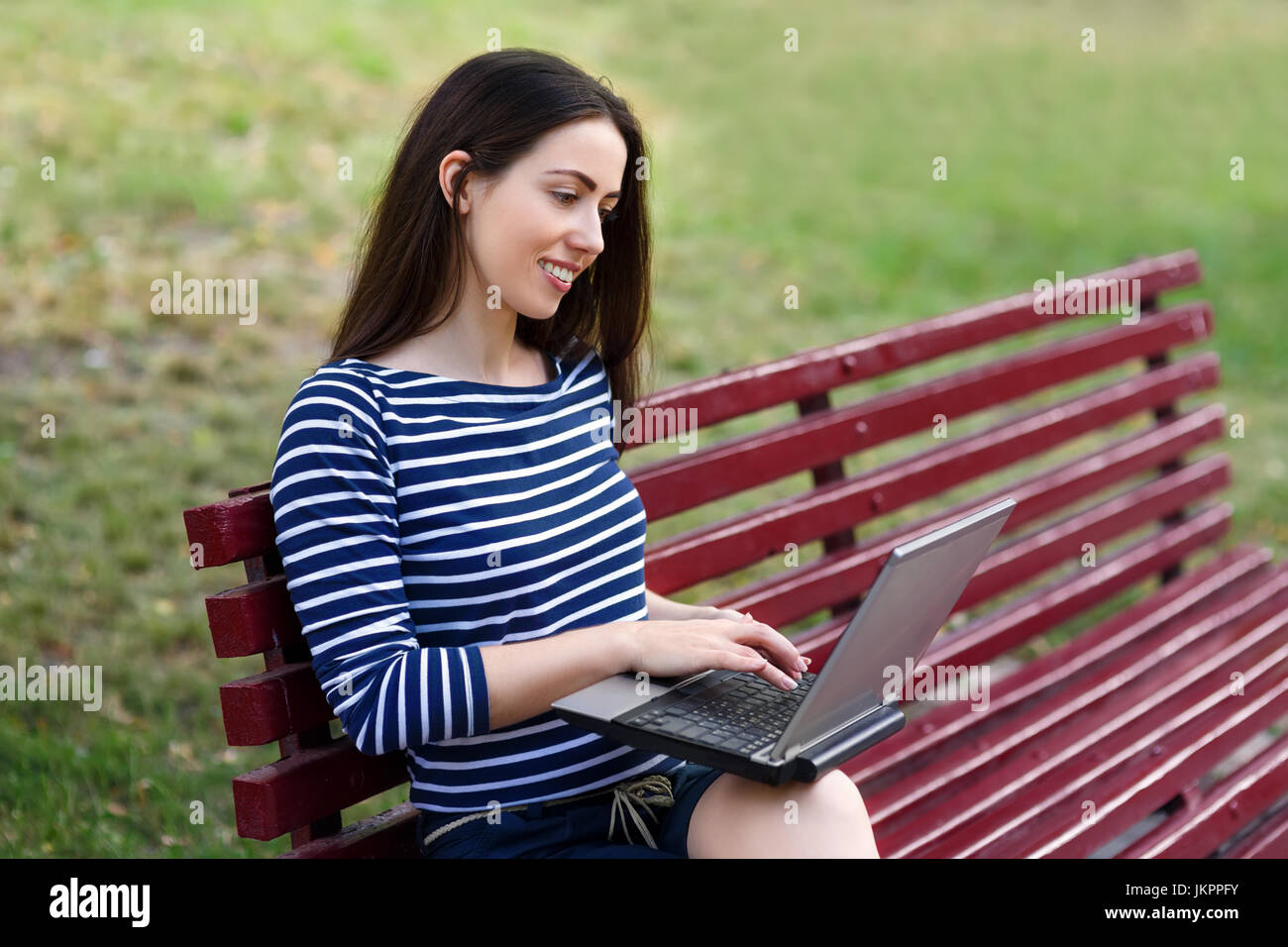 Woman working on laptop outdoors Banque D'Images