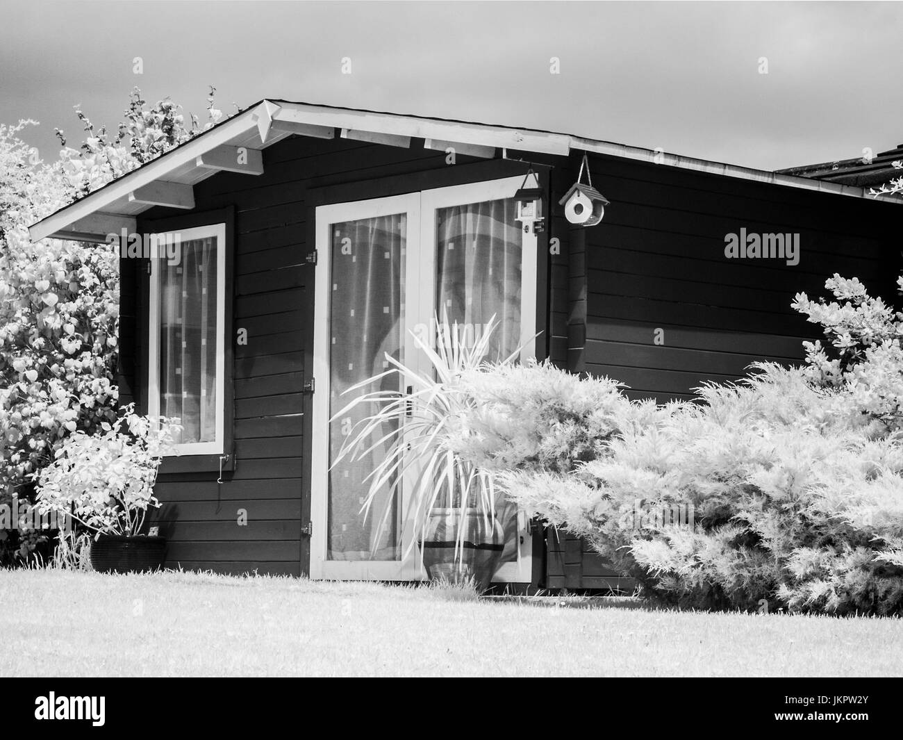 Un abri de jardin en bois de style chalet prises sur une caméra infrarouge converti. Banque D'Images