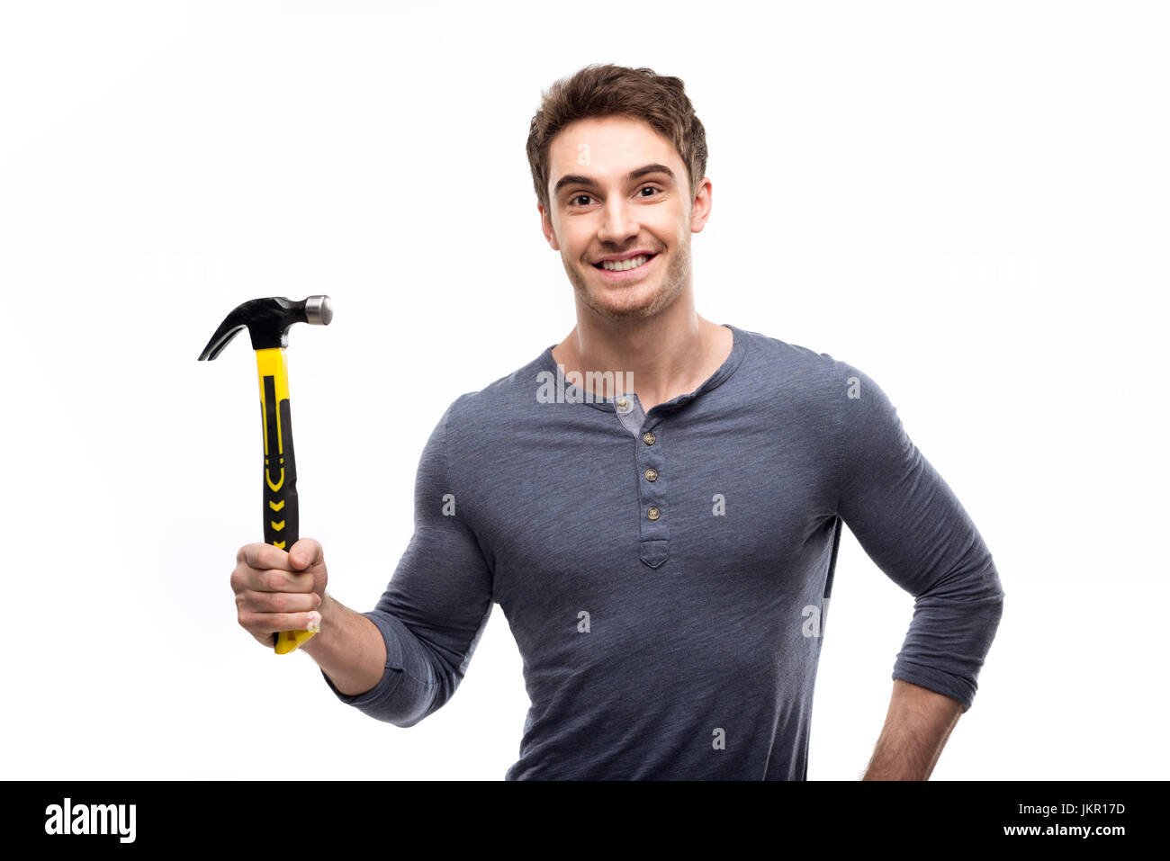 Handsome man holding hammer isolé sur blanc, concept outils bricoleur Banque D'Images