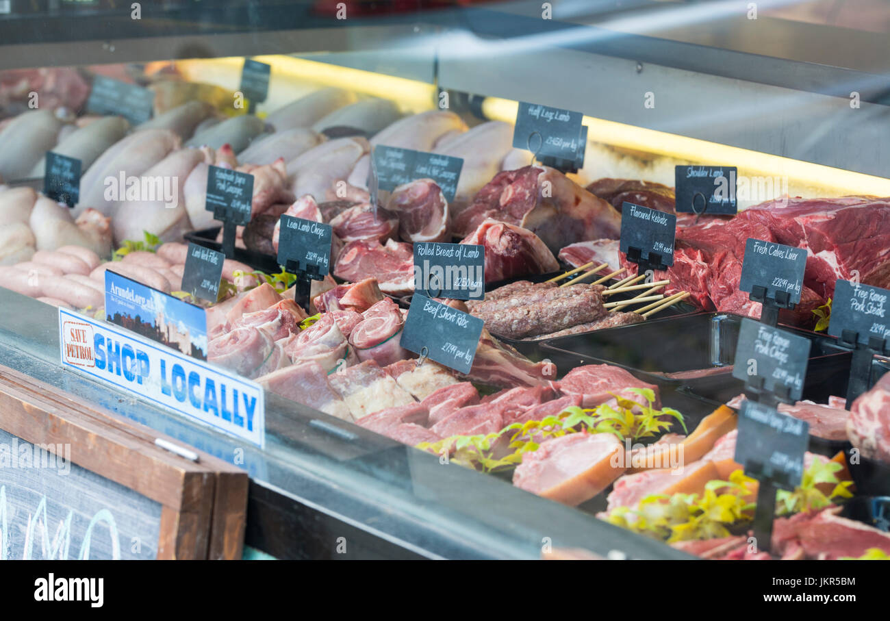 À travers une vitrine boucherie avec divers types de viande pour la vente au Royaume-Uni. Banque D'Images