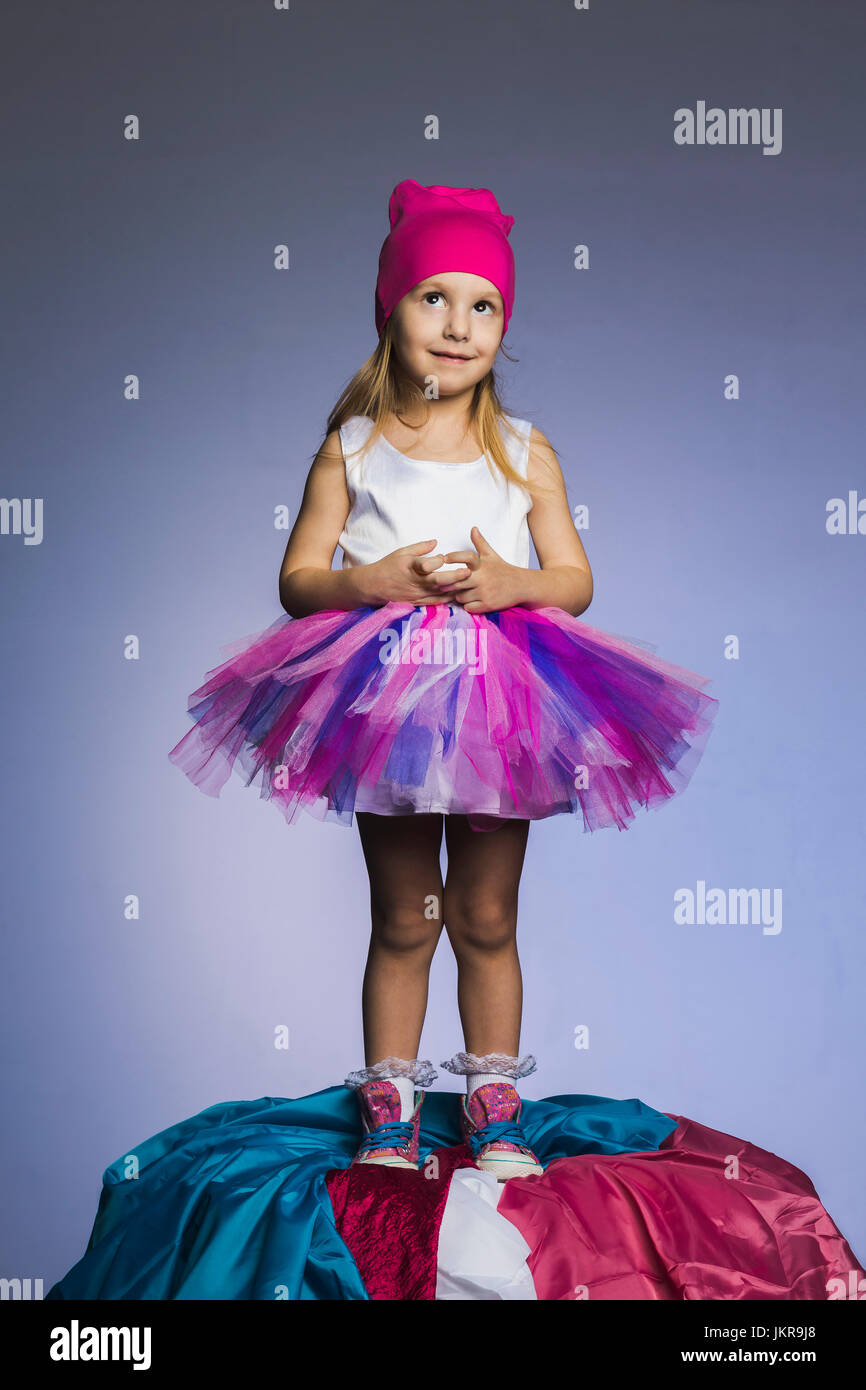 Cute girl wearing Knit hat jupe en tulle et Comité permanent sur les tissus  heap contre fond violet Photo Stock - Alamy