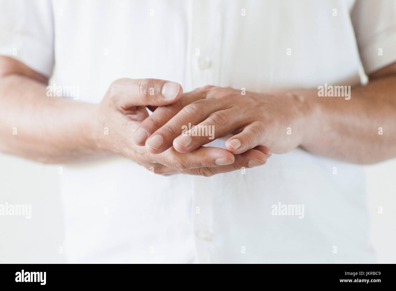 Portrait d'un homme portant des T-shirt with hands clasped Banque D'Images