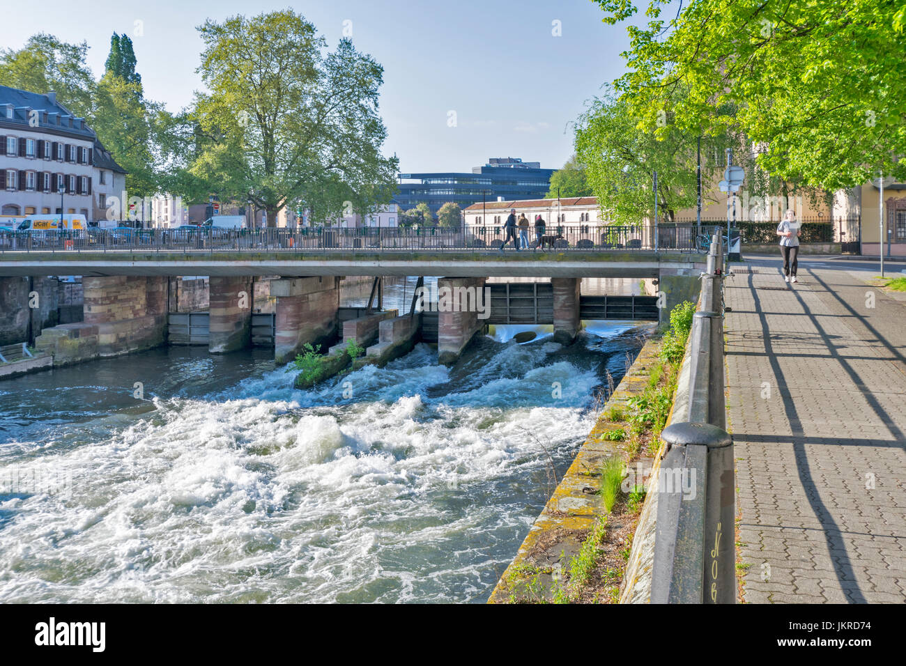 STRASBOURG PETITE FRANCE DE LA VILLE AVEC LA RIVIÈRE L'ILL ET VANNES ouvrir également quelques marcheurs ET TÔT LE MATIN UN JOGGER Banque D'Images