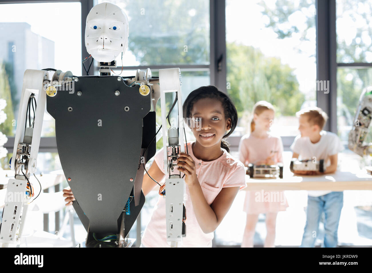 Gorgeous girl smiling at the camera de derrière un robot Banque D'Images