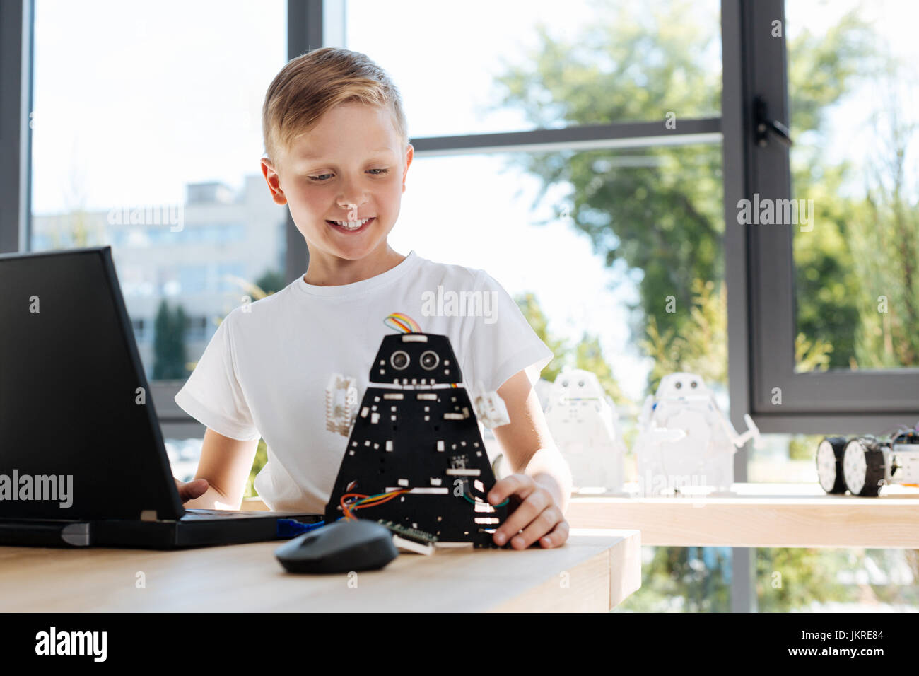 Garçon charmant d'être satisfait de son nouveau robot Banque D'Images